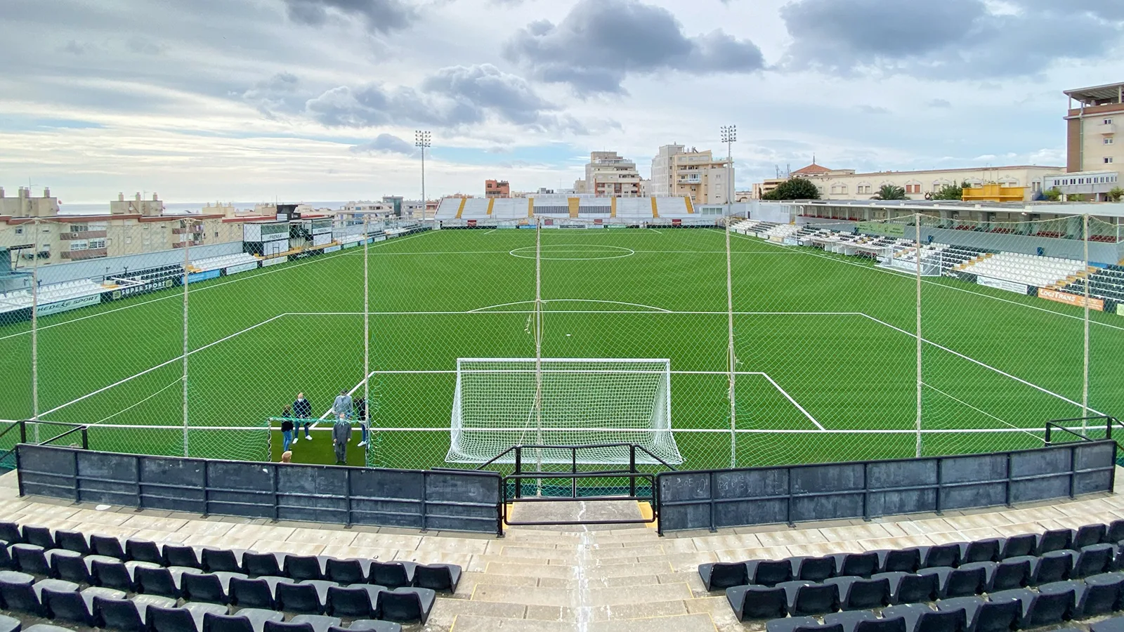 View of Ceuta's Alfonso Murube Stadium from the end stand, with the pitch and black-and-white stands