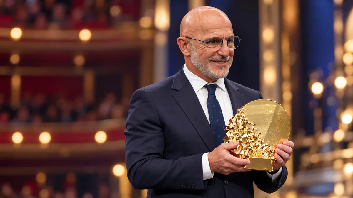 Luis de la Fuente holds the Johan Cruyff Trophy on an awards gala stage